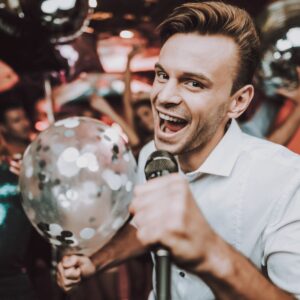 Party maker entertains the party by singing and entertaining guests with balloons