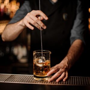 Barman prepara un cocktail artigianale per l’open bar di un ricevimento nuziale